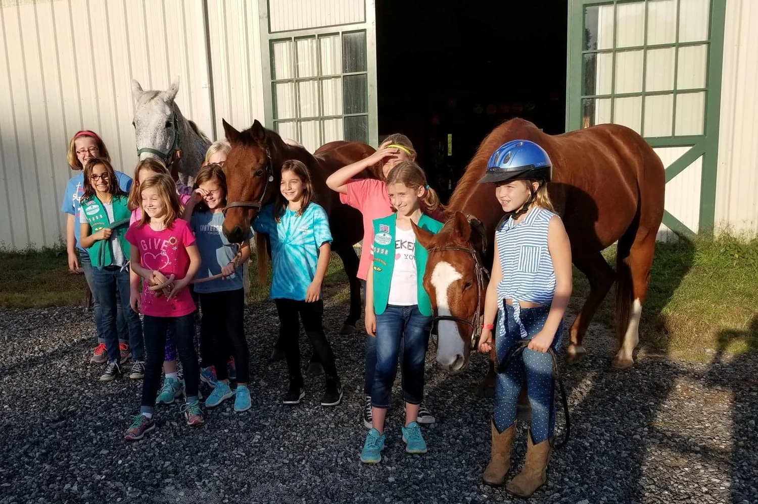 Birthday party group posing with horses in the barn