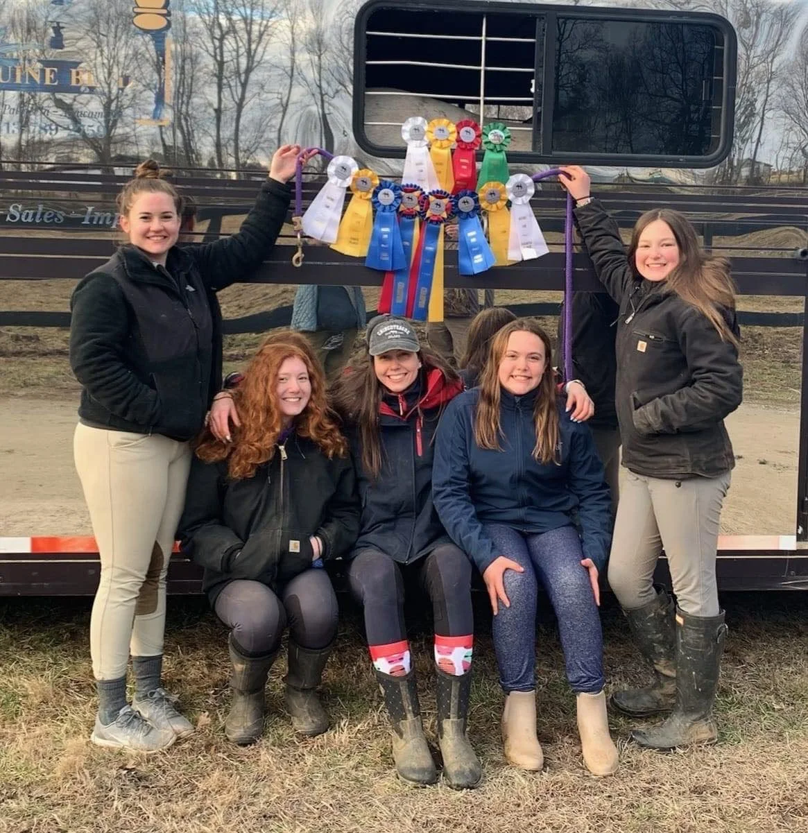 Team with show ribbons by the trailer