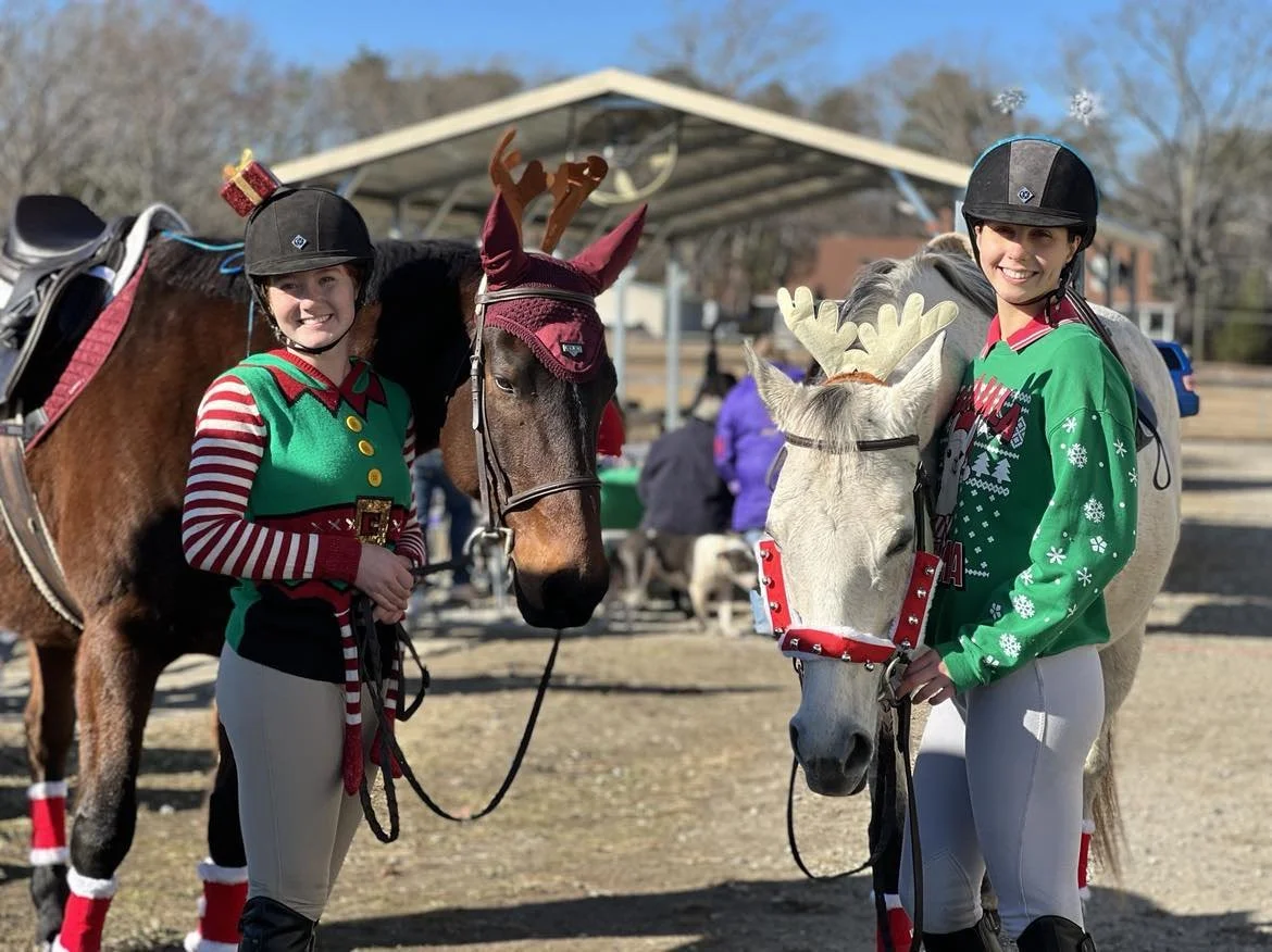 Two riders in holiday-themed costumes with their horses